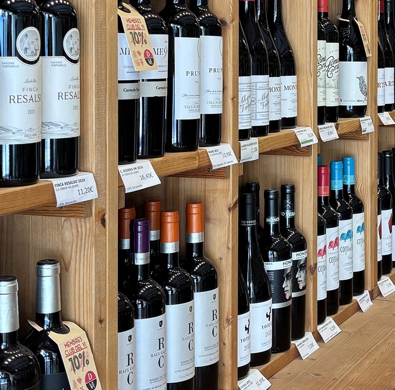 Estantes de madera con botellas de vino; espacio interior de DVI Vinoteca.