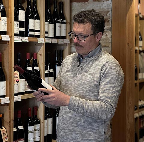 David Perramon entre estanterías de vinos en la vinoteca de Poblenou.