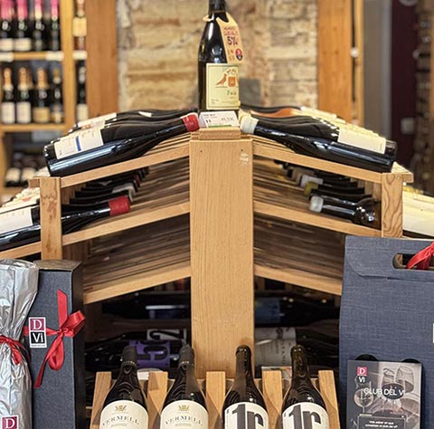 Estantes de madera con botellas de vino; espacio interior de DVI Vinoteca.